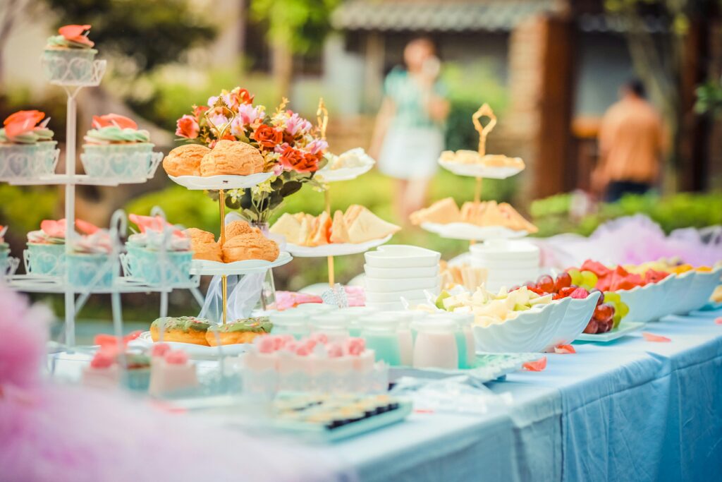Outdoor table laid out with food and flowers for a party