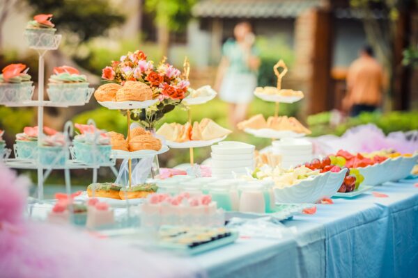 Outdoor table laid out with food and flowers for a party