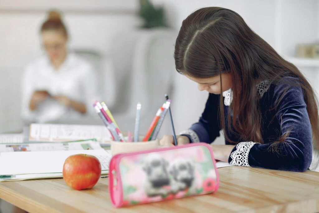 School girl writing on a desk in a classroom