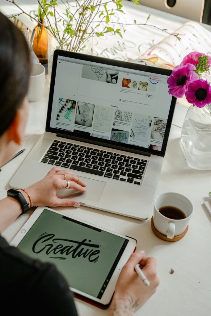 Woman creating digital art on a tablet and laptop