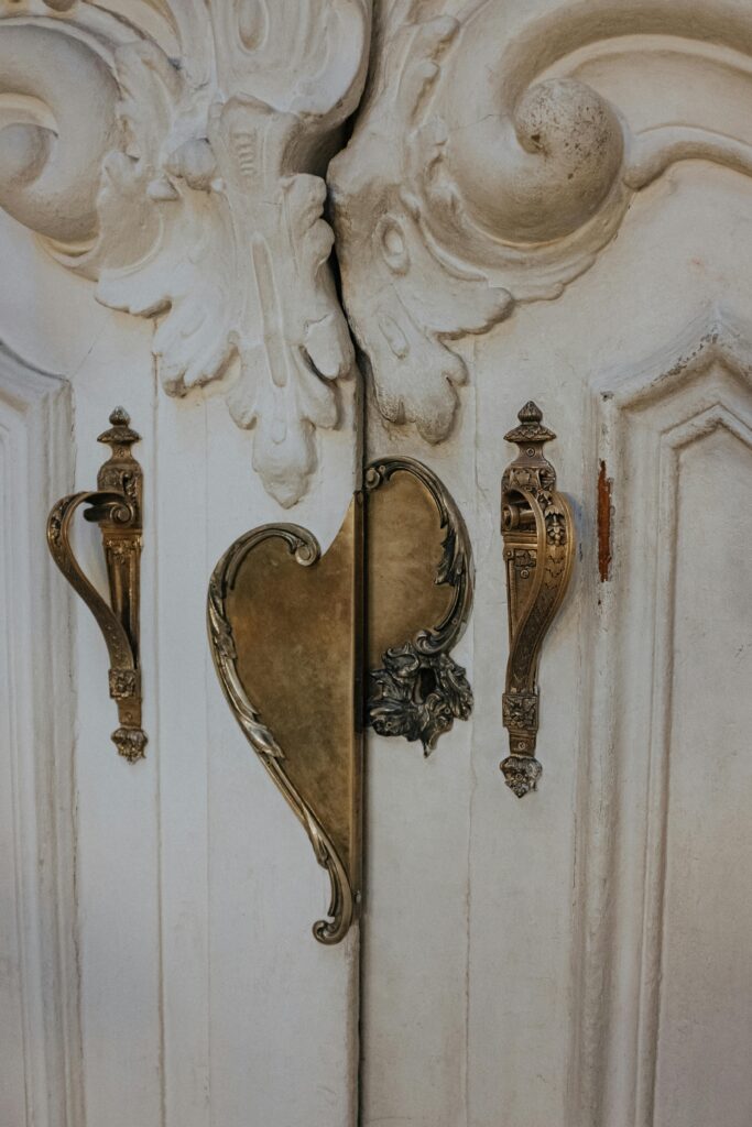 Antique door handles on a a beautiful, ornate door