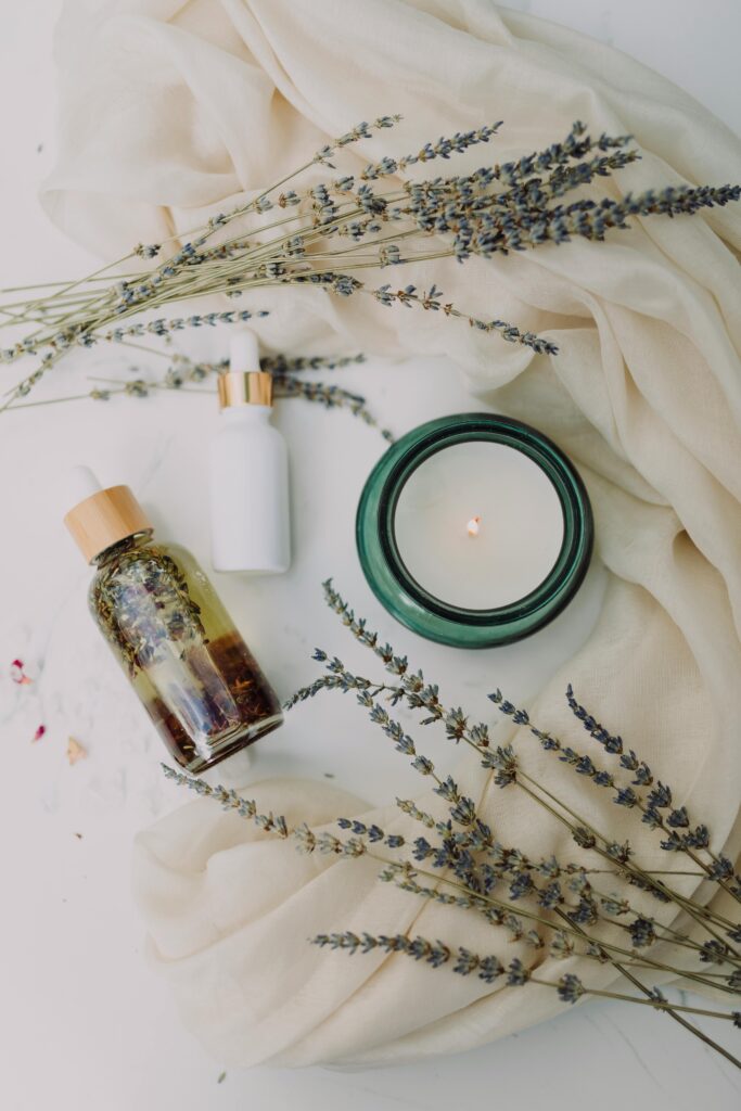 Skincare treatments in a flatlay design with a candle and lavender sprigs