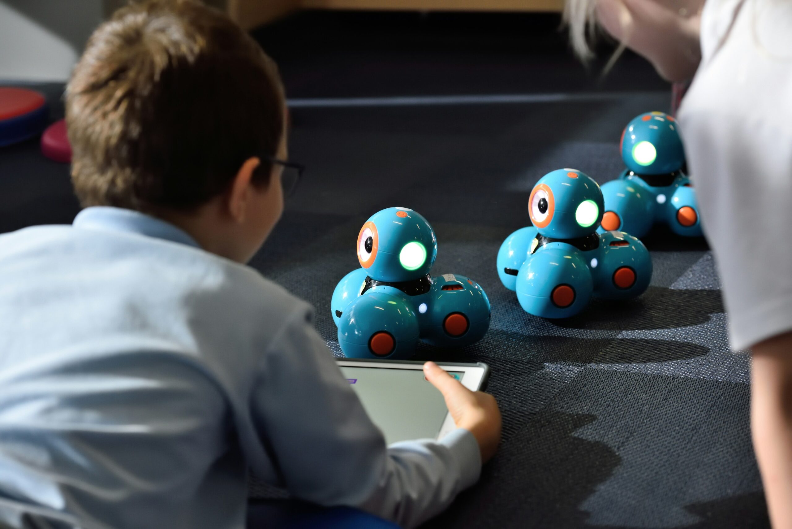 Child doing STEM education with a tablet and robots