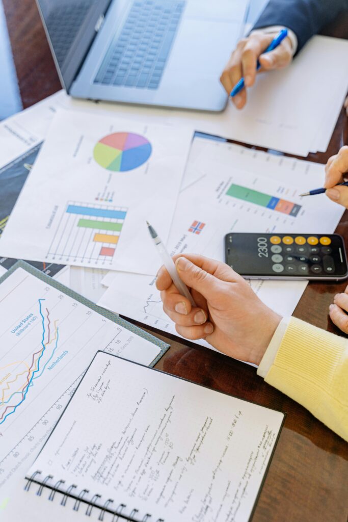 Charts, a calculator and laptop on a desk