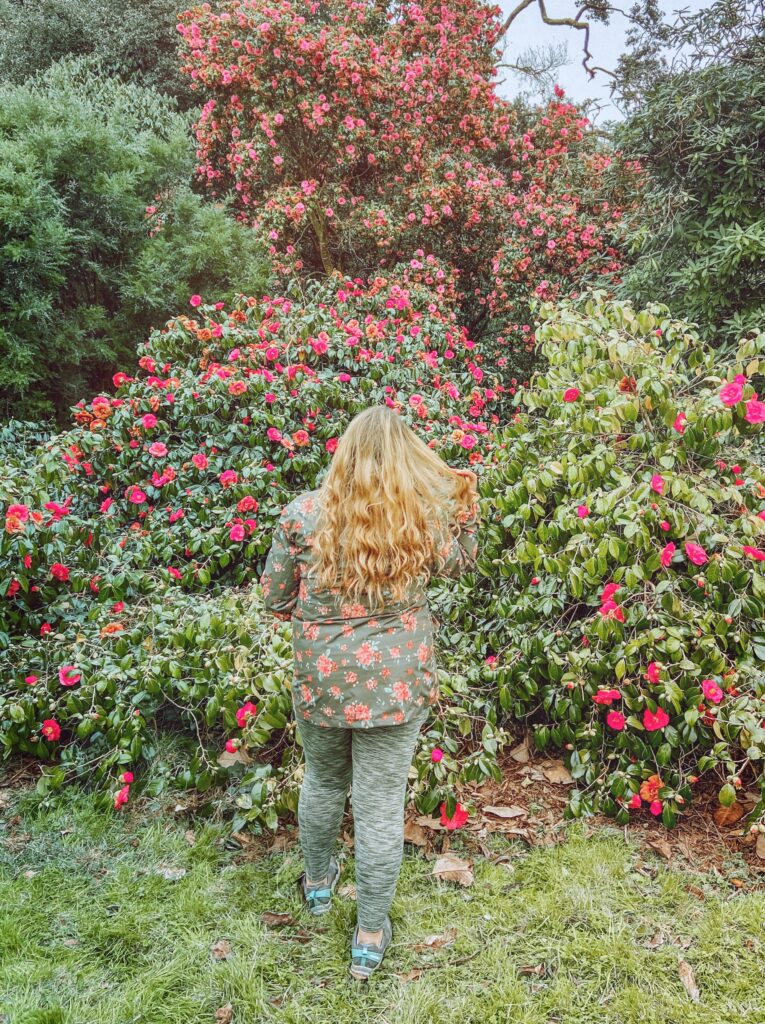 Woman standing in front of pink flowers