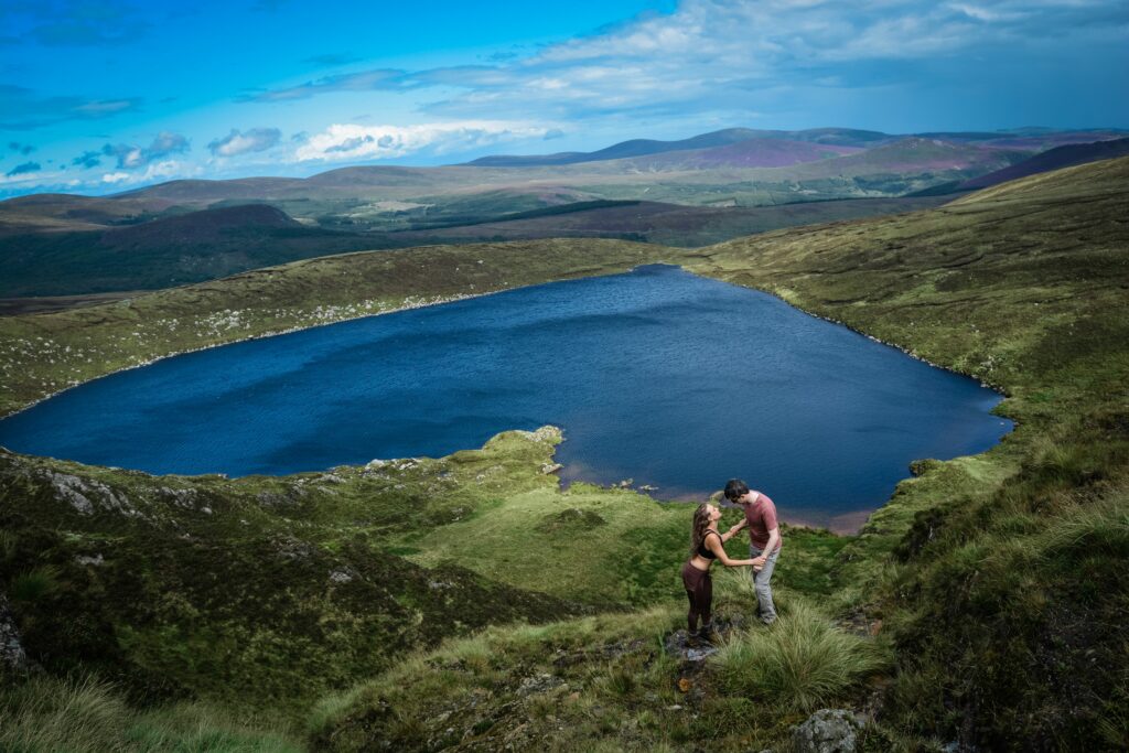 Man and woman standing at Lough Ouler, the heart shaped lake in County Wicklow, Ireland