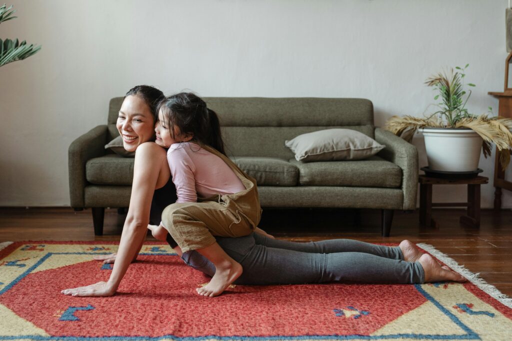 Photo of girl hugging her mom while practicing yoga