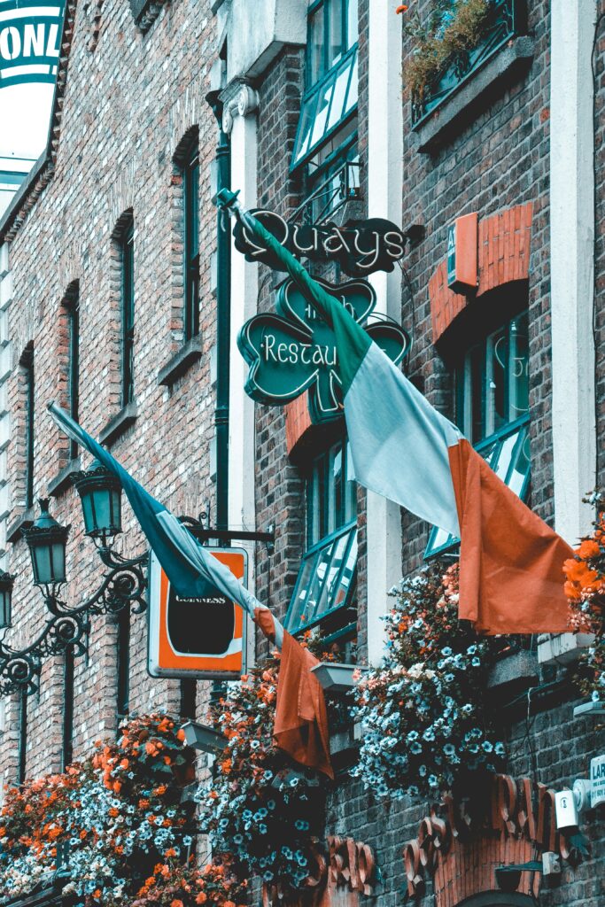 Irish flags on a building with flowers
