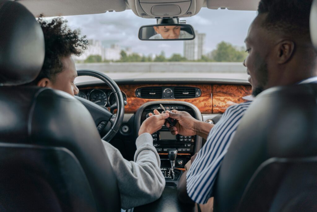 Father handing son keys to a car