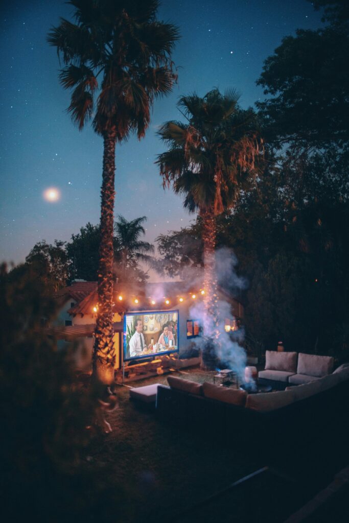 Palm trees near projection screen and outdoor sitting area