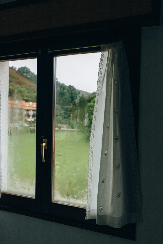 White curtains on a window with condensation