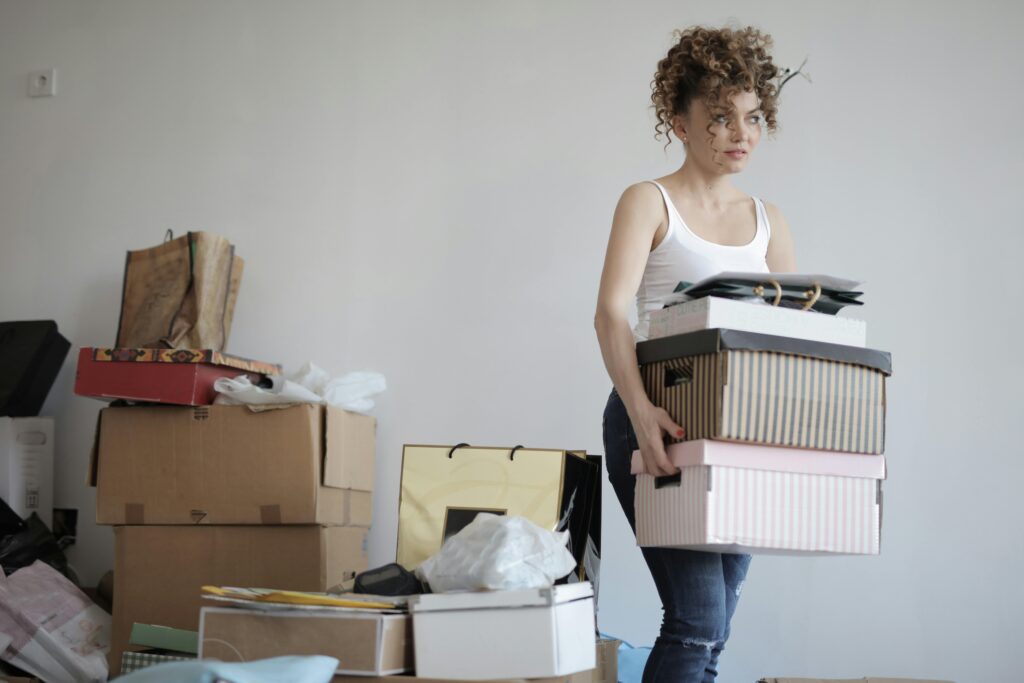 Woman carrying boxes with boxes behind her