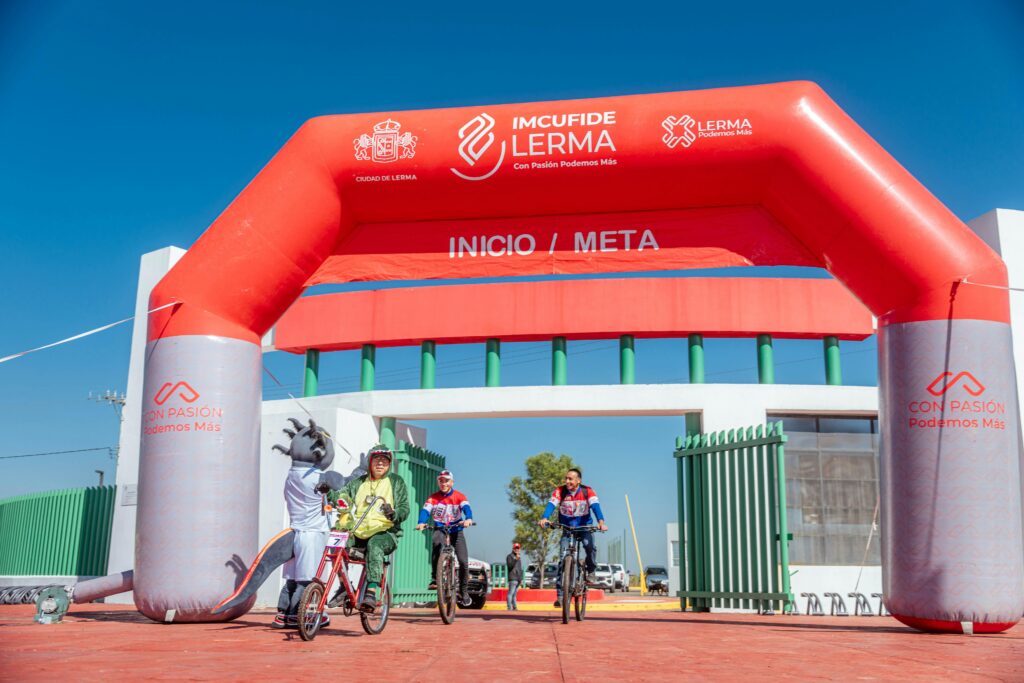 People on bikes under an inflatable arch