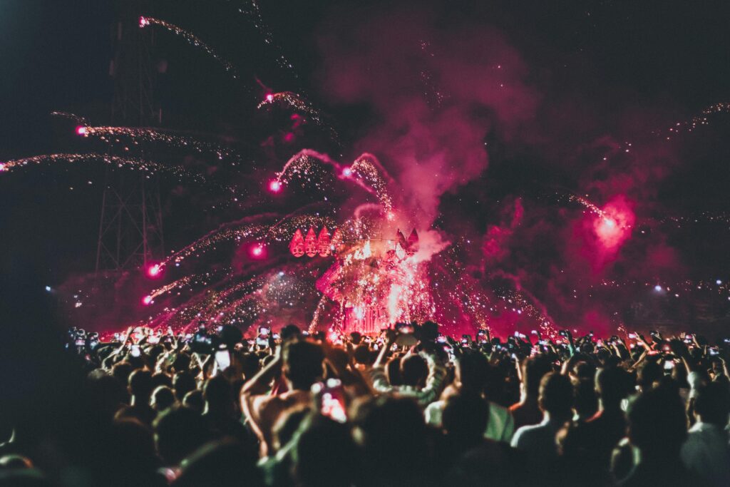 Large crowd gathered outdoors watching fireworks display