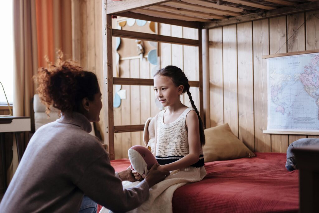 Mother and daughter talking in a bedroom