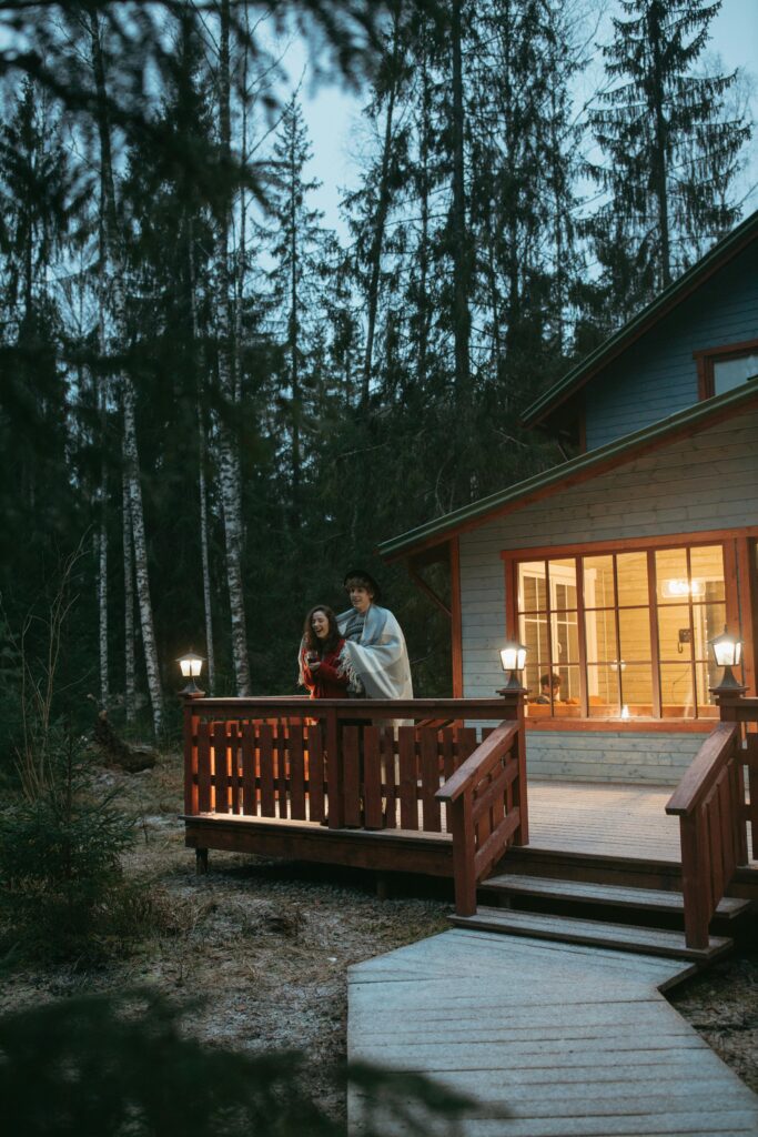 Couple wrapped in blankets standing outside a lodge