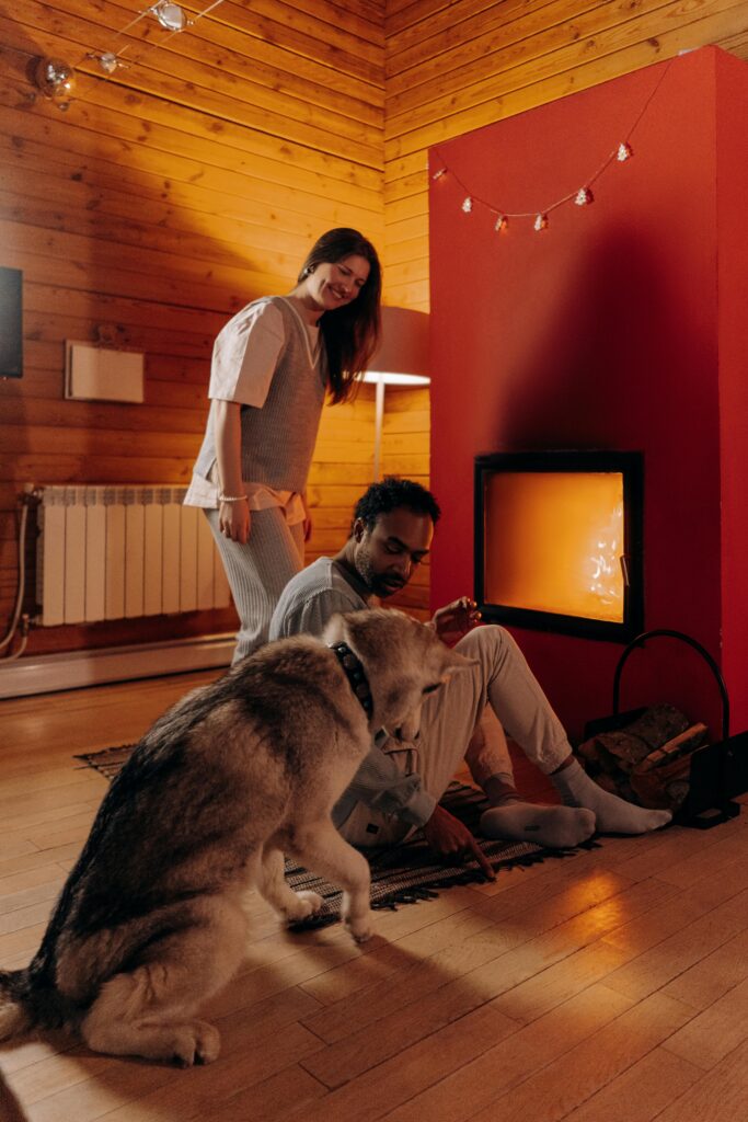 Man, woman and dog next to a fire