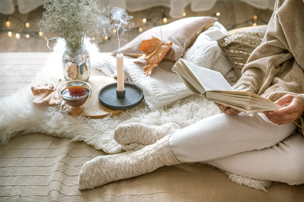 Woman relaxing in a cosy space at home reading a book