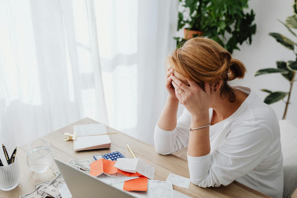 Woman with her head in her hands sitting at a desk