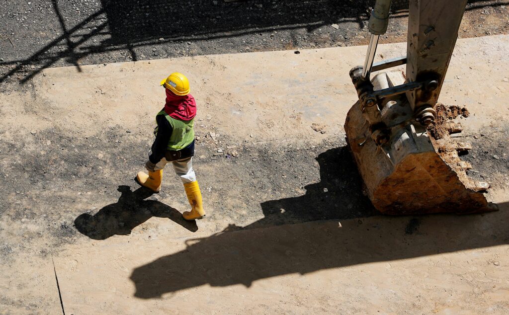 Aerial view of construction worker with excavator bucket