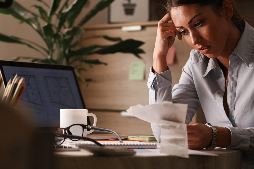 Business woman looking at receipts with a worried expression