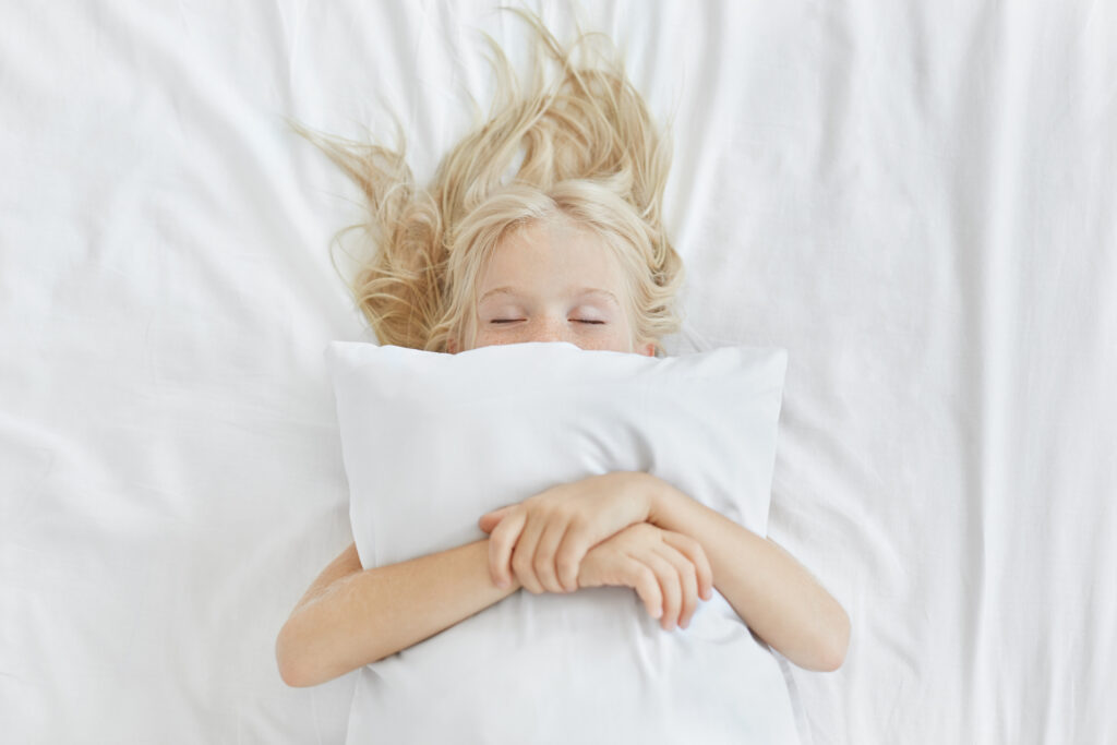 Girl lying on a bed with a pillow