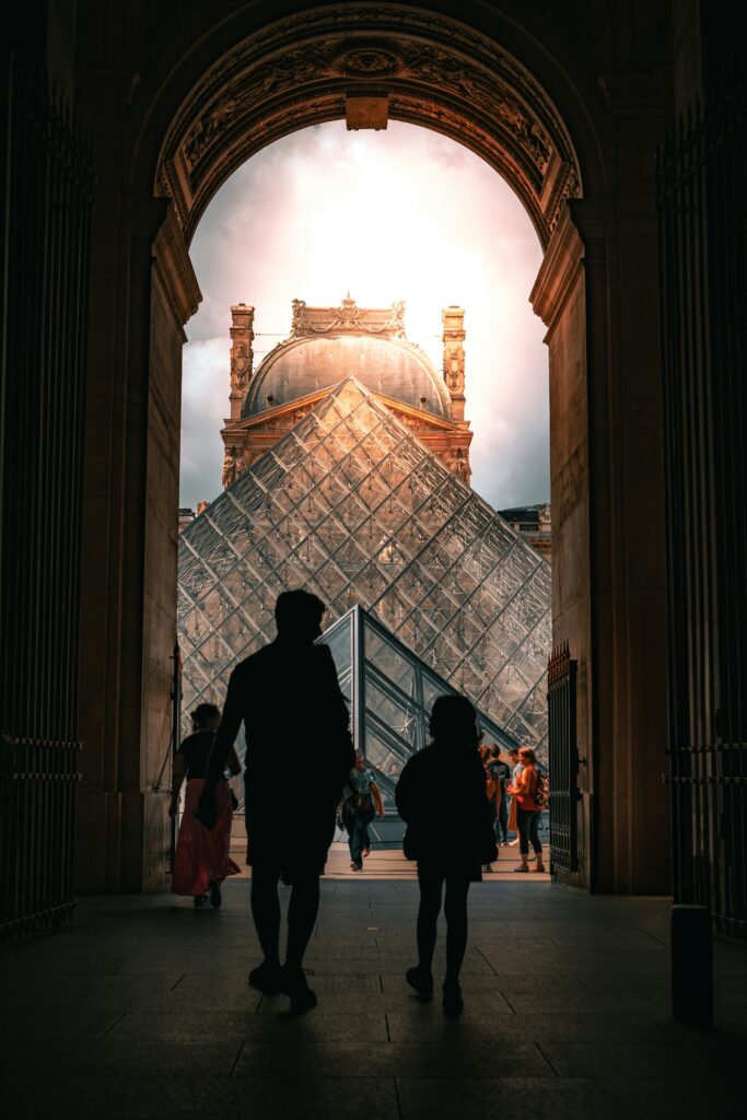 Father and child walking into the Louvre Museum in Paris