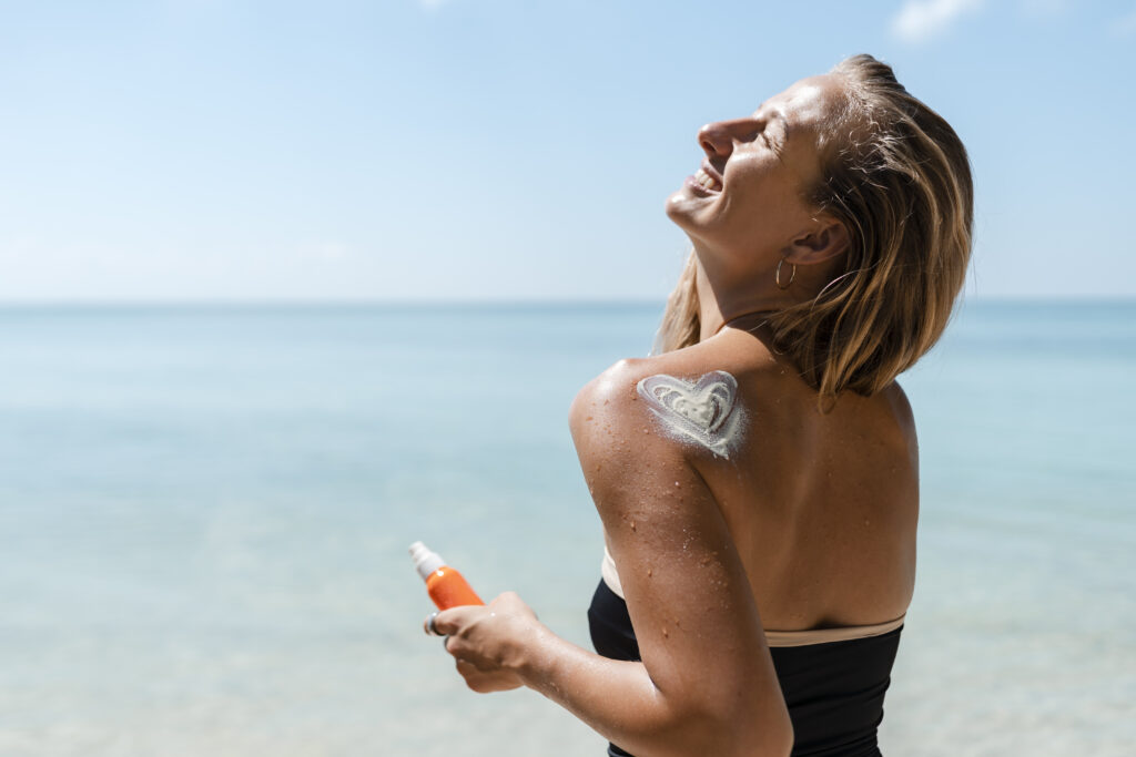 Woman applying sunscreen at the beach