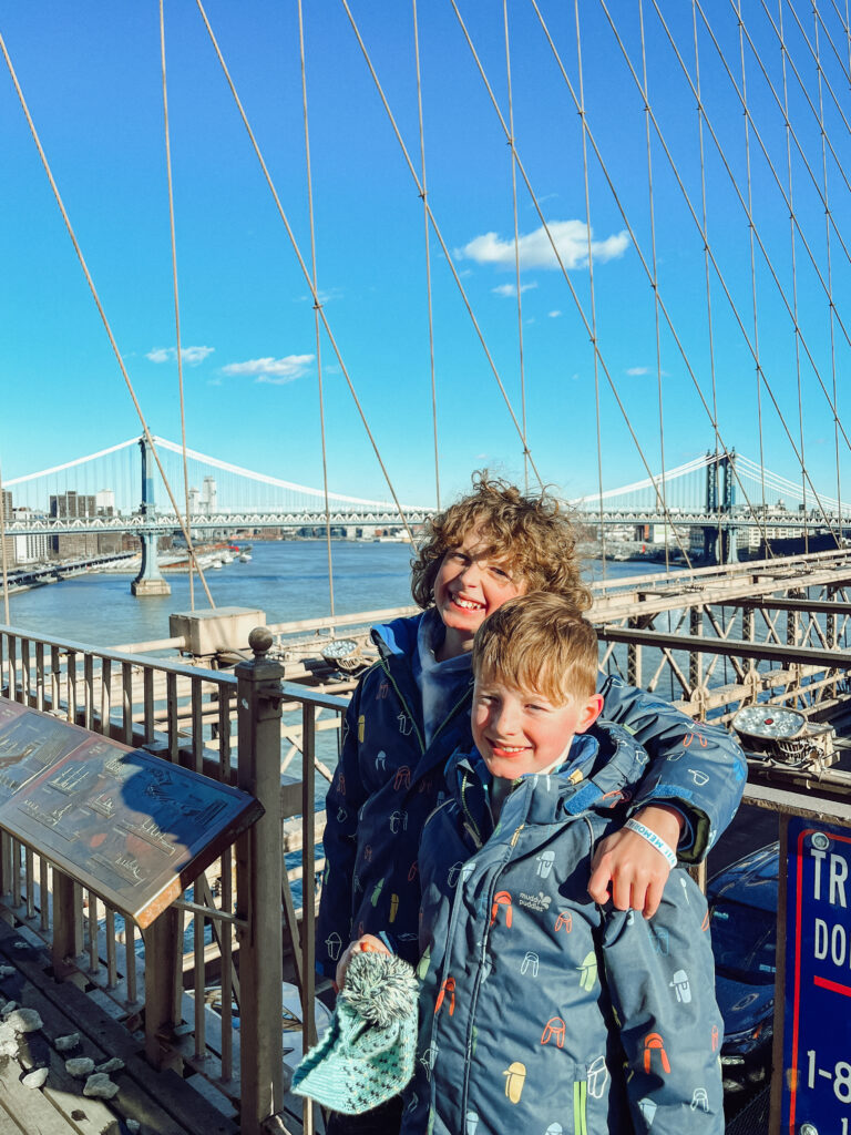 Two boys standing on the Brooklyn Bridge