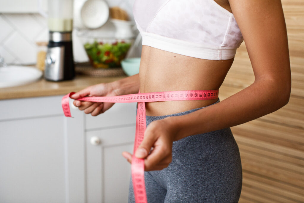 Woman measuring her waist