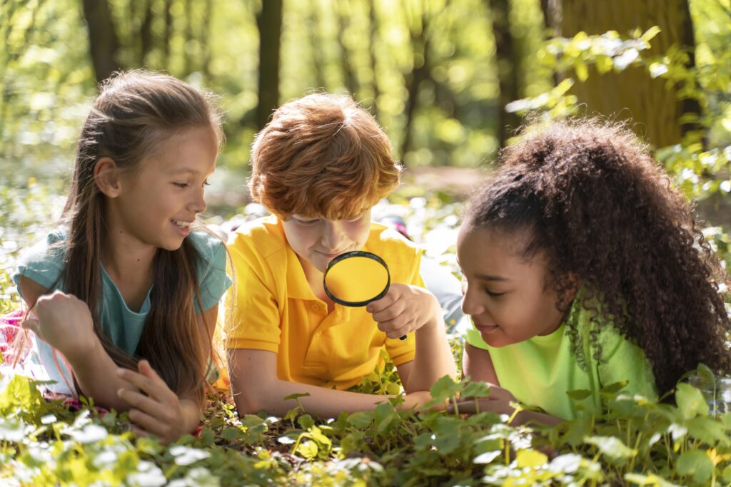 Kids exploring nature together with a magnifying glass