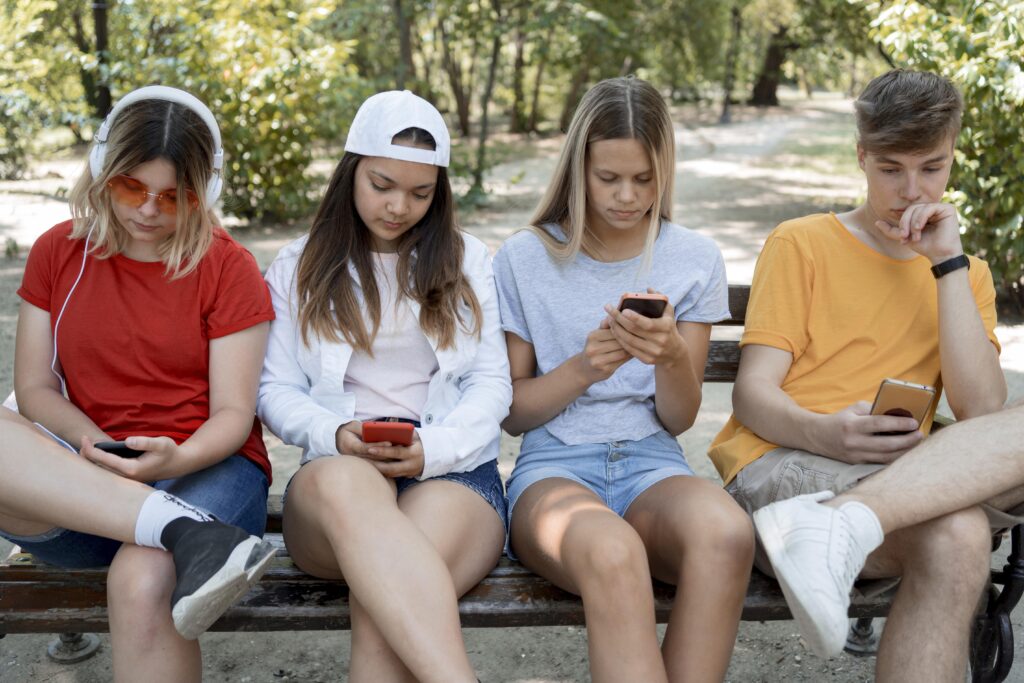 4 teenage friends using phones