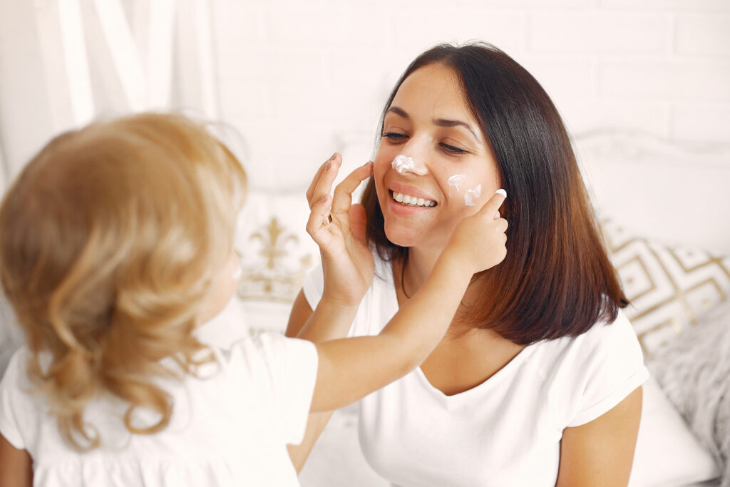 Mother and daughter applying skincare