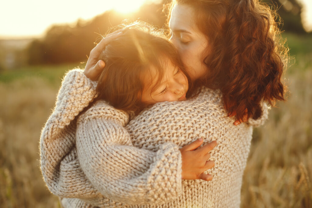 Mother and daughter hugging in the sunlight