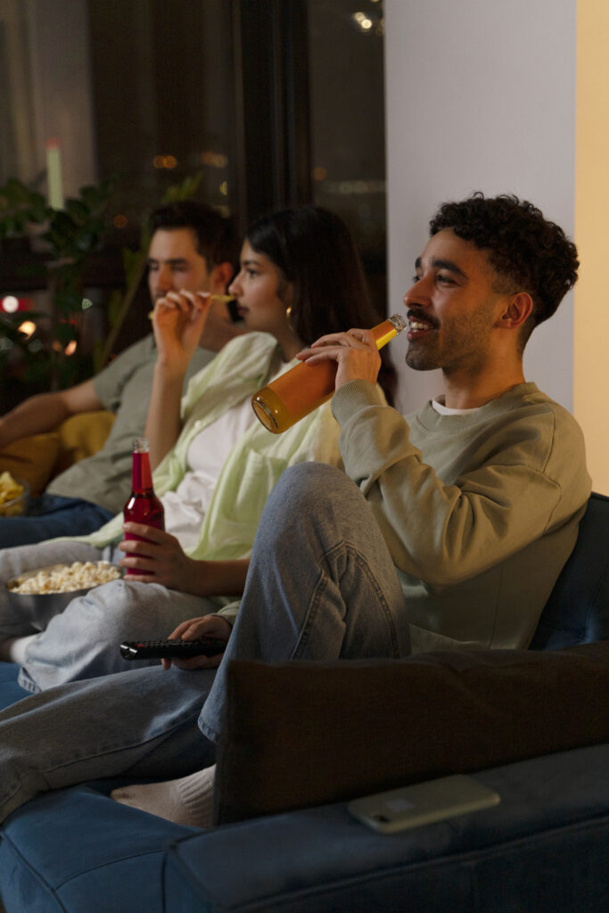 Friends enjoying food, drinks and a movie