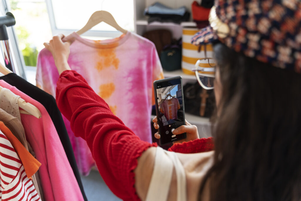 Side view of woman photographing a t-shirt