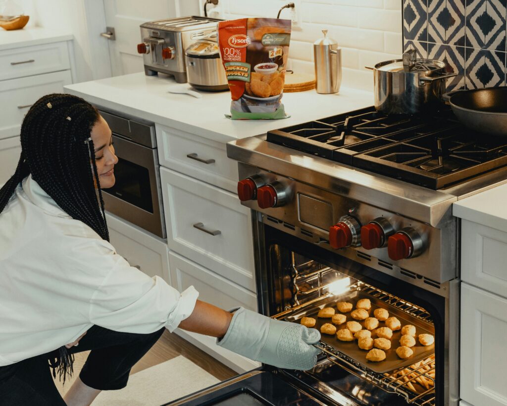 Woman by the oven taking out food
