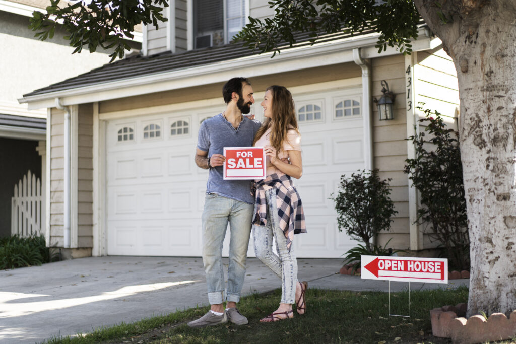 Couple standing outside a house that's for sale