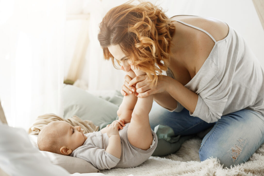 Happy mother kissing baby's feet
