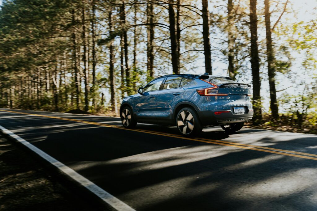 Blue electric car on a wooded road