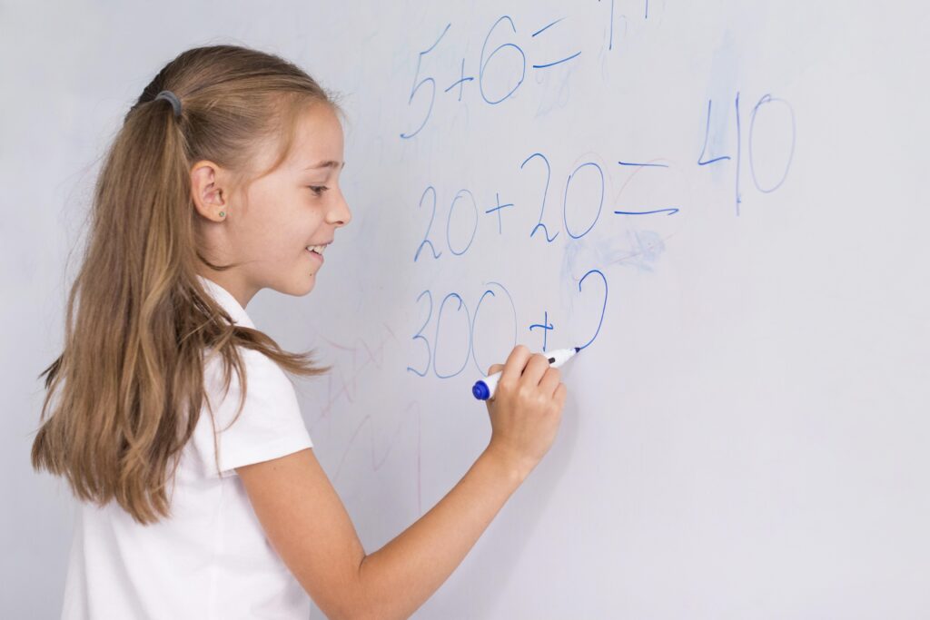 Girl doing maths on a whiteboard