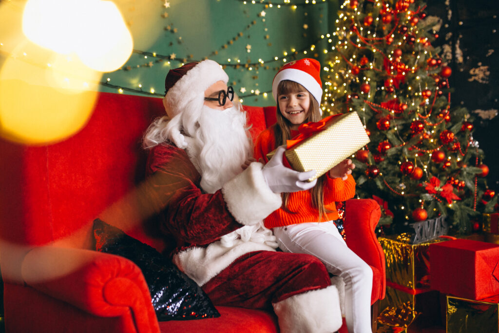 Little girl with Santa and presents