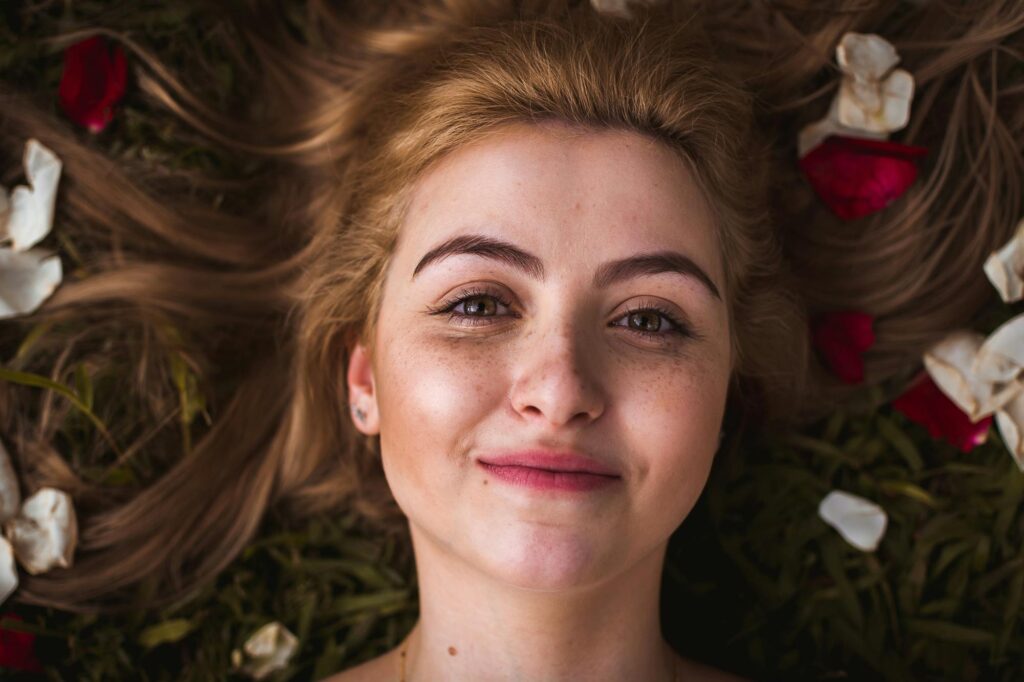 Woman lying on ground with petals