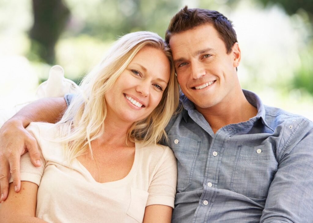 Blonde woman and a dark haired man sitting beside each other