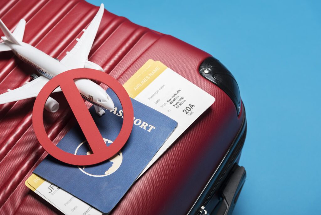 Luggage with passport and cancelled sign on airplane