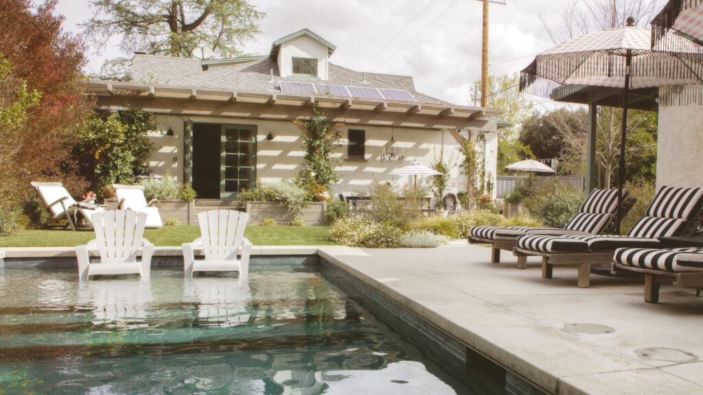 Home swimming pool with wooden chairs