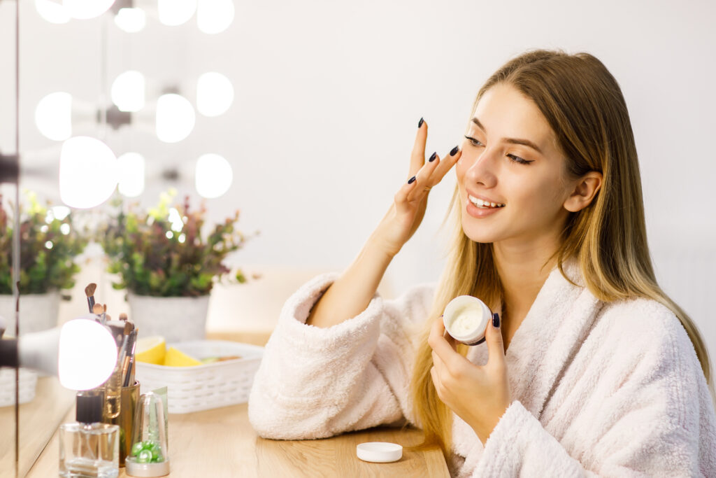 Woman applying skincare in front of a mirror