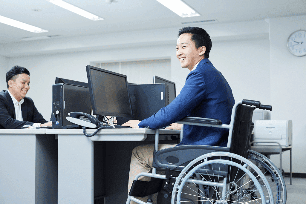 Man in a wheelchair at his desk in an office