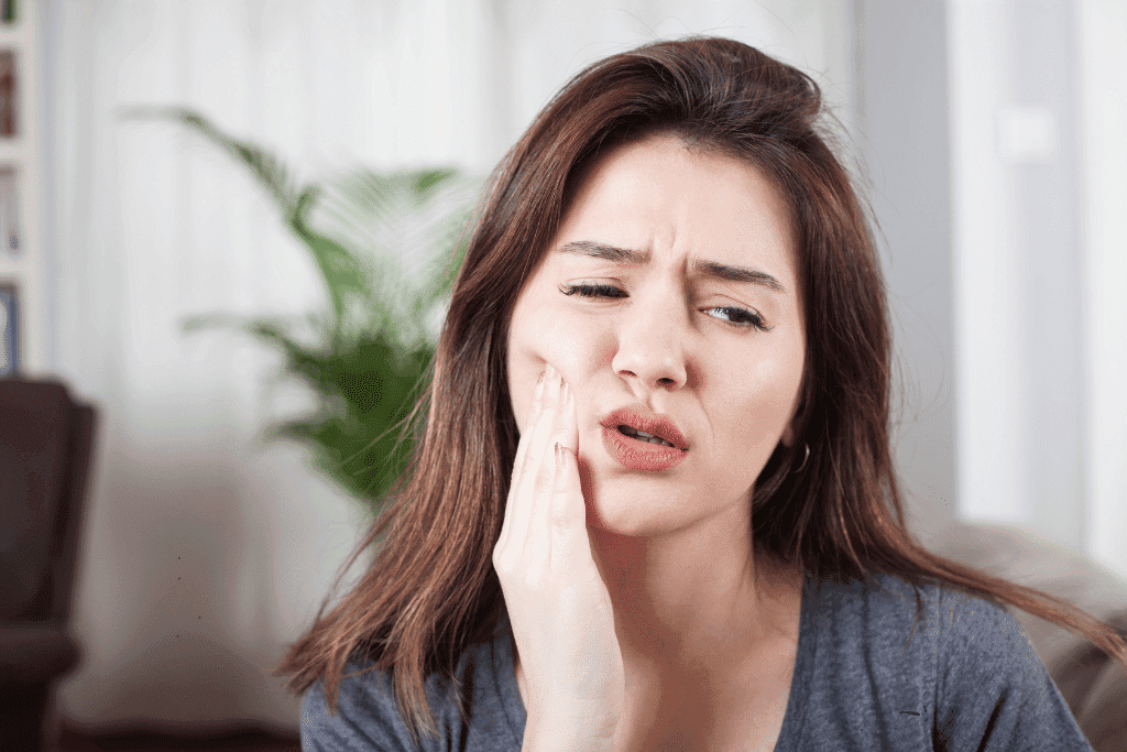 Teenage girl holding the side of her face due to toothache