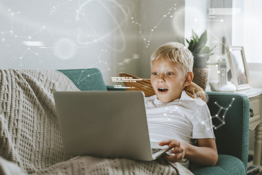 Young boy playing coding games on a laptop